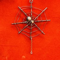 Copper spider web ornament red background