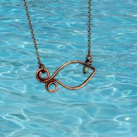 Copper fish necklace, water background.