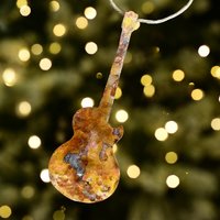 Copper electric guitar ornament on blurred twinkle lights background
