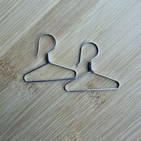 Sterling coat hanger earrings, laying flat on table