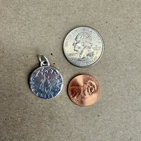 Deep Creek Lake charm next to penny and quarter coins to show size