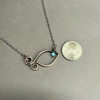 Copper fish necklace, size comparison with coin.