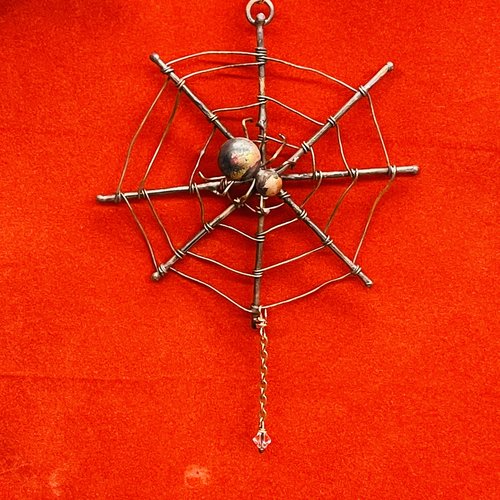 Copper spider web ornament red background