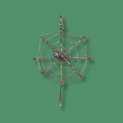 copper spider web ornament green background