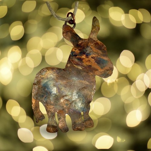 Copper donkey silhouette ornament, blurry twinkle lights background.