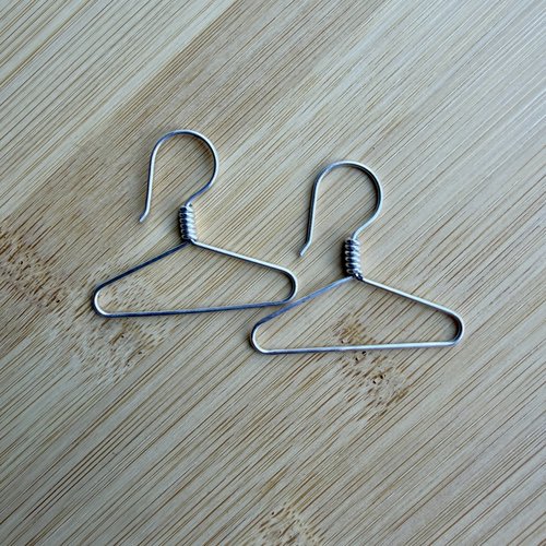 Sterling coat hanger earrings, laying flat on table