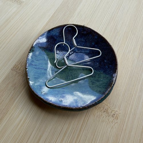 Sterling coat hanger earrings in shallow pottery dish