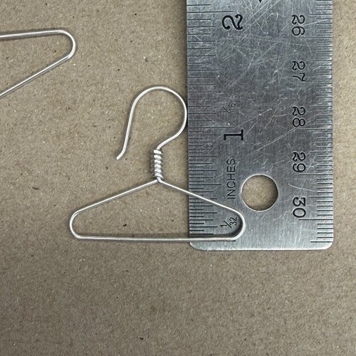Coat hanger earrings showing height next to ruler