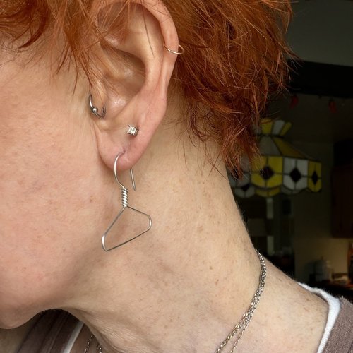 Coat hanger earrings in ear