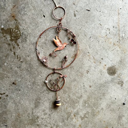Copper hummingbird in circles mobile, full view, laying flat.