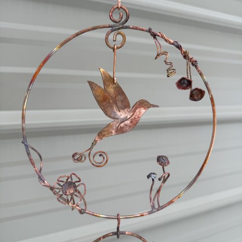 Copper hummingbird in circles mobile, close up view.